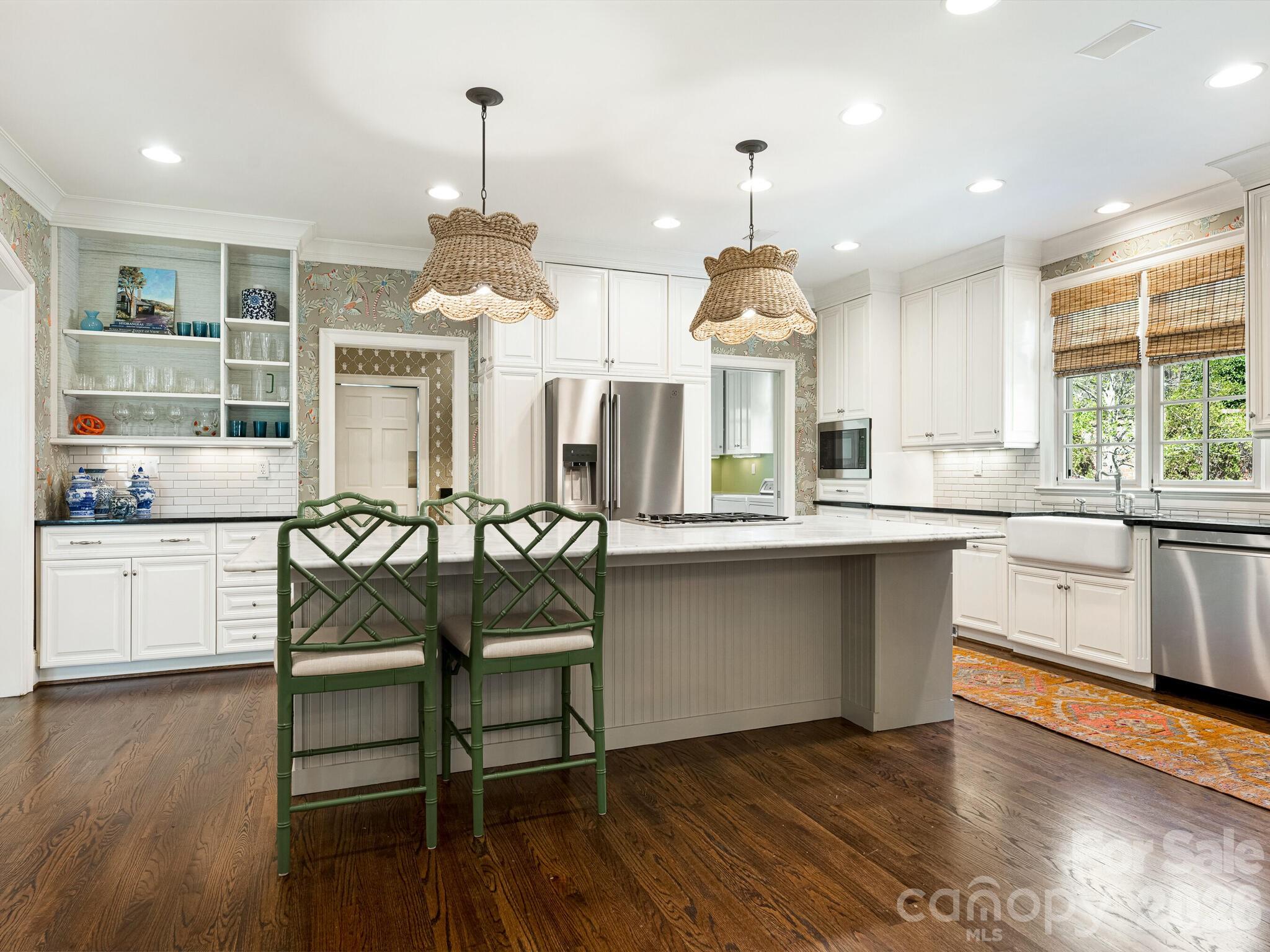 1413 Andover Road Charlotte, NC 28211 - Photo 9 of 41 a kitchen with stainless steel appliances a dining table chairs stove and white cabinets