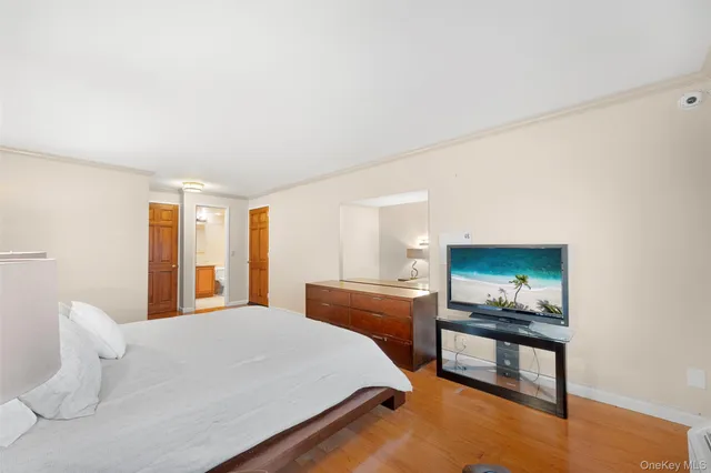 a spacious bedroom with a bed and wooden floor