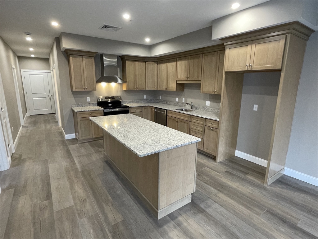 1 Brattle Street, Unit 4 Worcester, MA 01606 - Photo 5 of 21 a kitchen with stainless steel appliances granite countertop a stove and a refrigerator
