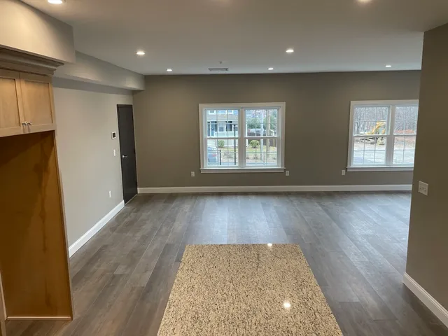 an entryway with wooden floor and cabinets