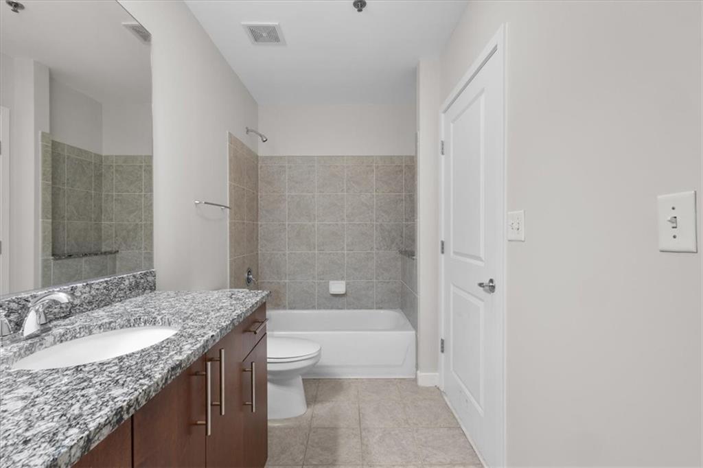 250 Pharr Road Northeast, Unit 309 Atlanta, GA 30305 - Photo 12 of 37 a bathroom with a granite countertop sink a toilet and shower