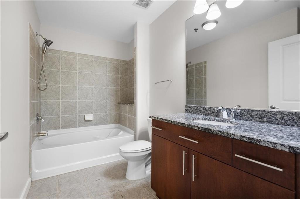 250 Pharr Road Northeast, Unit 309 Atlanta, GA 30305 - Photo 18 of 37 a bathroom with a granite countertop sink a toilet and bathtub