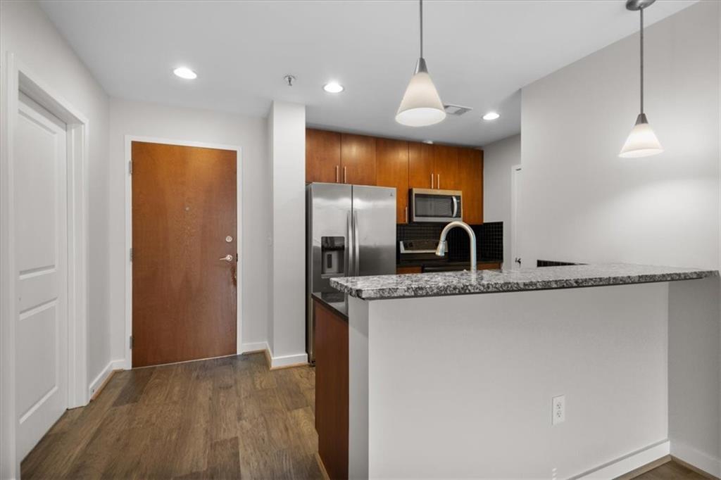 250 Pharr Road Northeast, Unit 309 Atlanta, GA 30305 - Photo 4 of 37 a kitchen with stainless steel appliances granite countertop a sink and a refrigerator