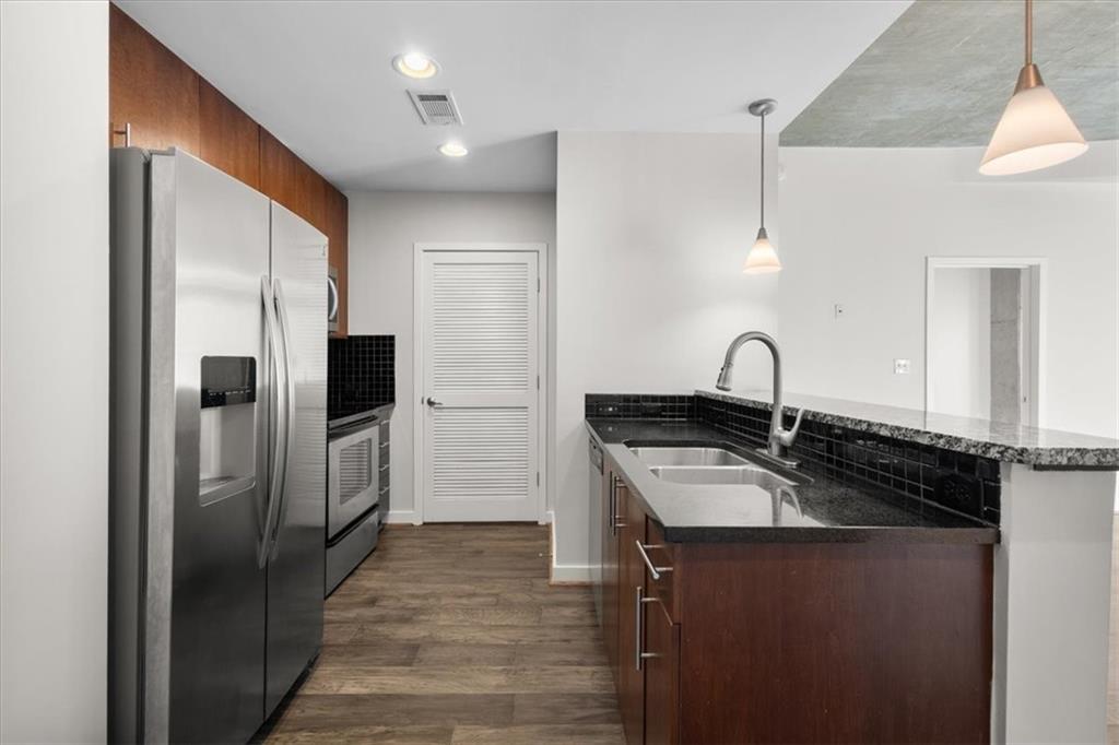 250 Pharr Road Northeast, Unit 309 Atlanta, GA 30305 - Photo 5 of 37 a kitchen with granite countertop a refrigerator and a sink