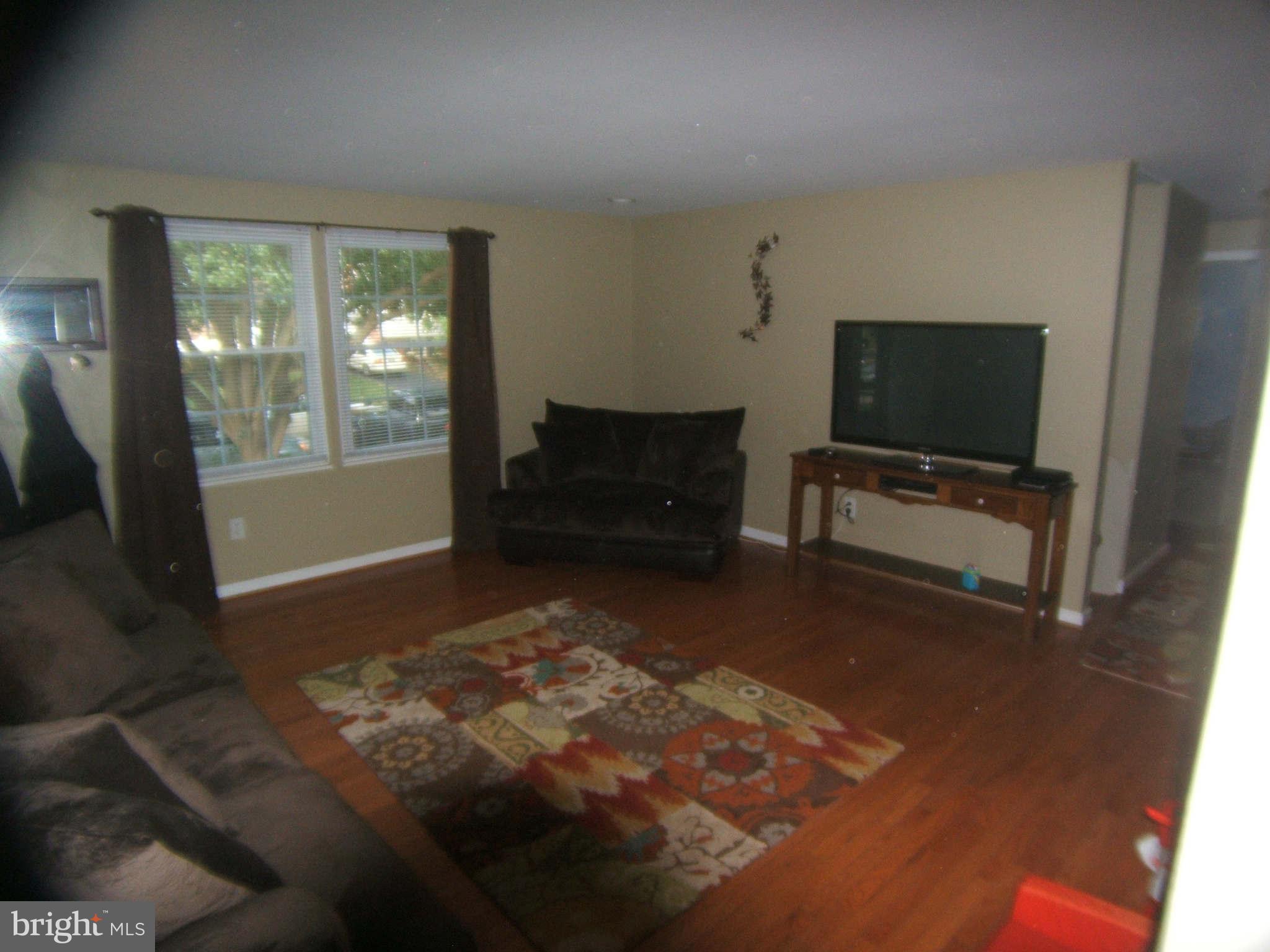 19113 Staleybridge Road Germantown, MD 20876 - Photo 2 of 17 a living room with furniture and a flat screen tv