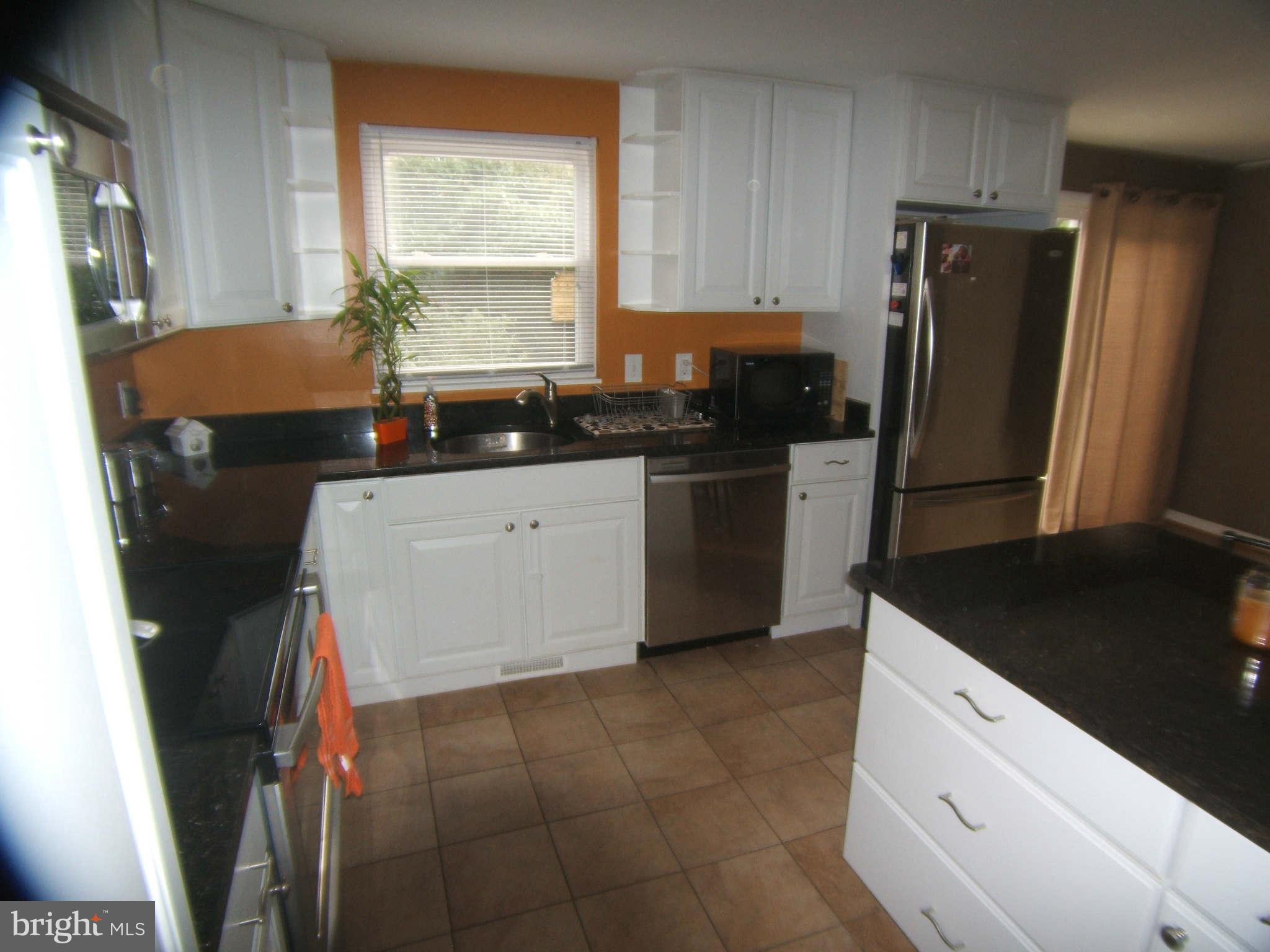 19113 Staleybridge Road Germantown, MD 20876 - Photo 11 of 17 a kitchen with a refrigerator sink and stove