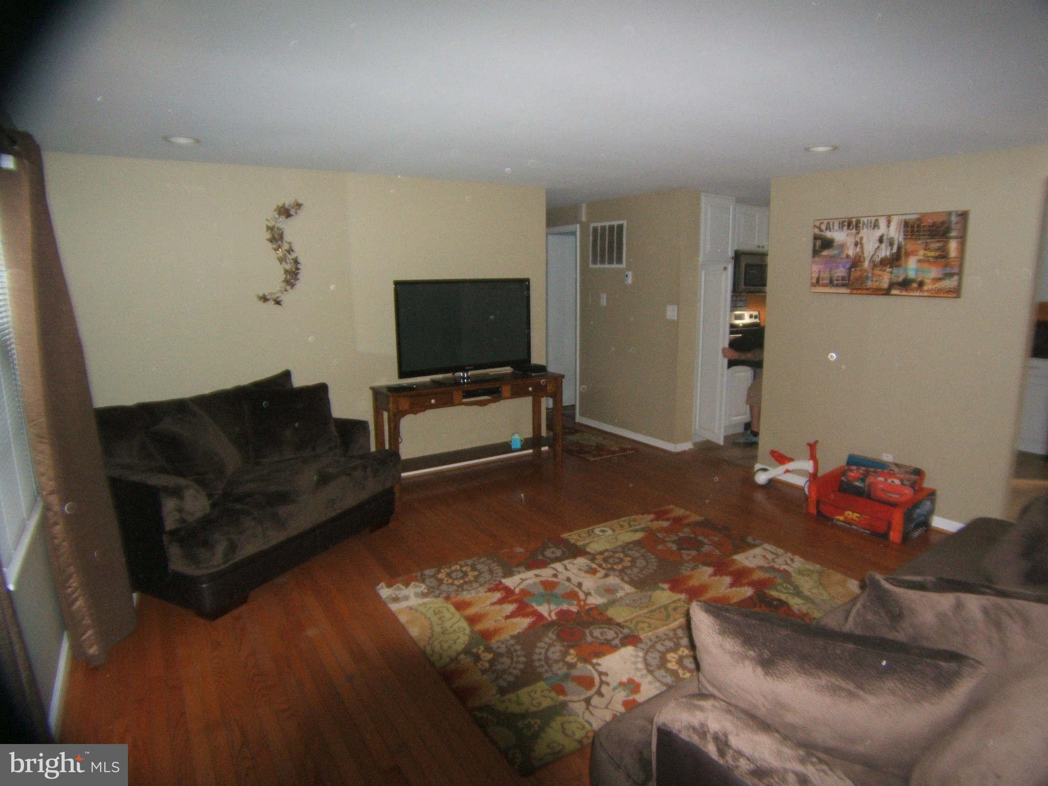19113 Staleybridge Road Germantown, MD 20876 - Photo 3 of 17 a living room with furniture and a flat screen tv
