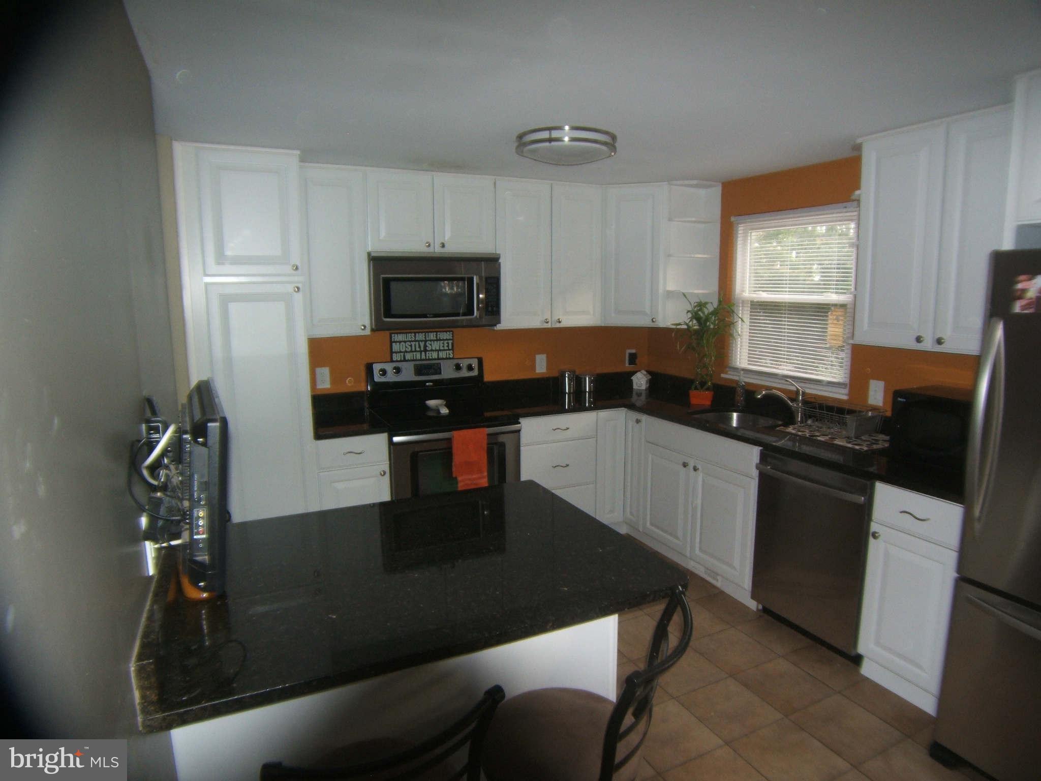 19113 Staleybridge Road Germantown, MD 20876 - Photo 8 of 17 a kitchen with granite countertop a sink appliances and cabinets