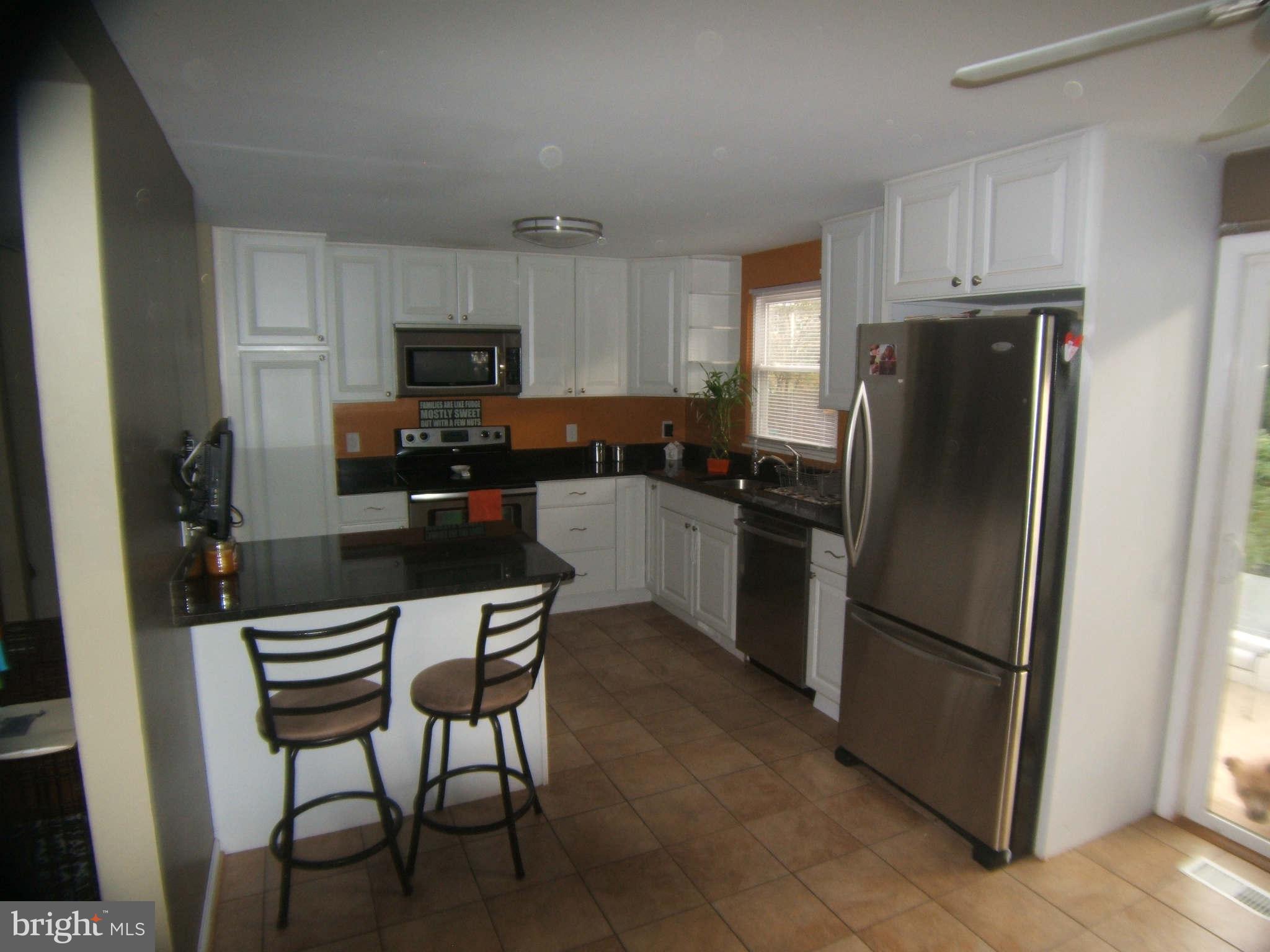 19113 Staleybridge Road Germantown, MD 20876 - Photo 9 of 17 a kitchen with stainless steel appliances a refrigerator a stove a sink and a refrigerator