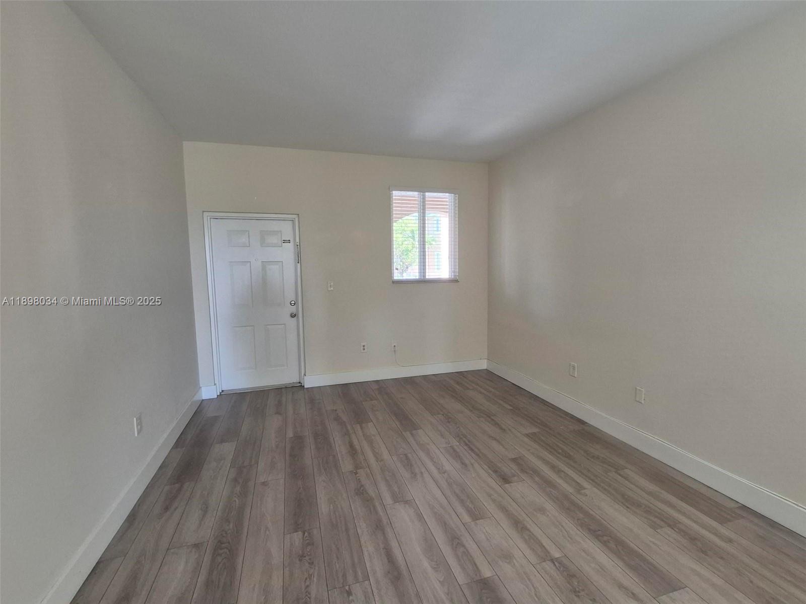 17820 Northwest 73rd Avenue, Unit 2011 Hialeah, FL 33015 - Photo 1 of 16 an empty room with wooden floor and windows
