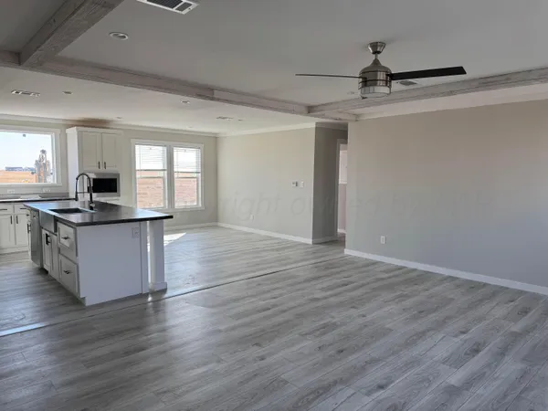 a kitchen with stainless steel appliances kitchen island granite countertop a sink cabinets and wooden floor
