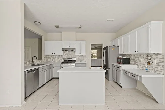 a kitchen with stainless steel appliances a stove refrigerator sink and cabinets