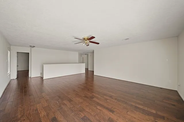 a view of a livingroom with wooden floor and a ceiling fan