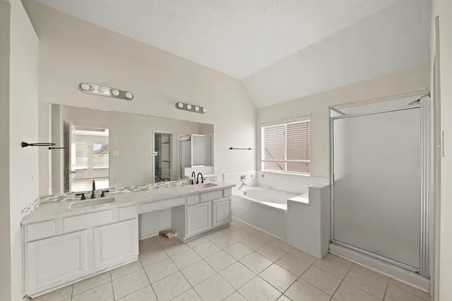 a large bathroom with a double vanity sink a mirror and a bathtub