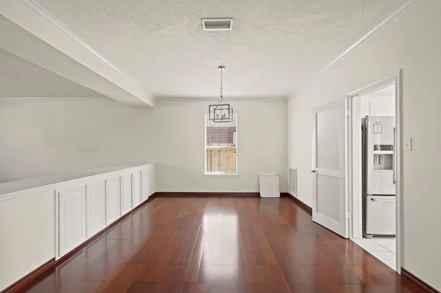a hallway with wooden floor closet and windows