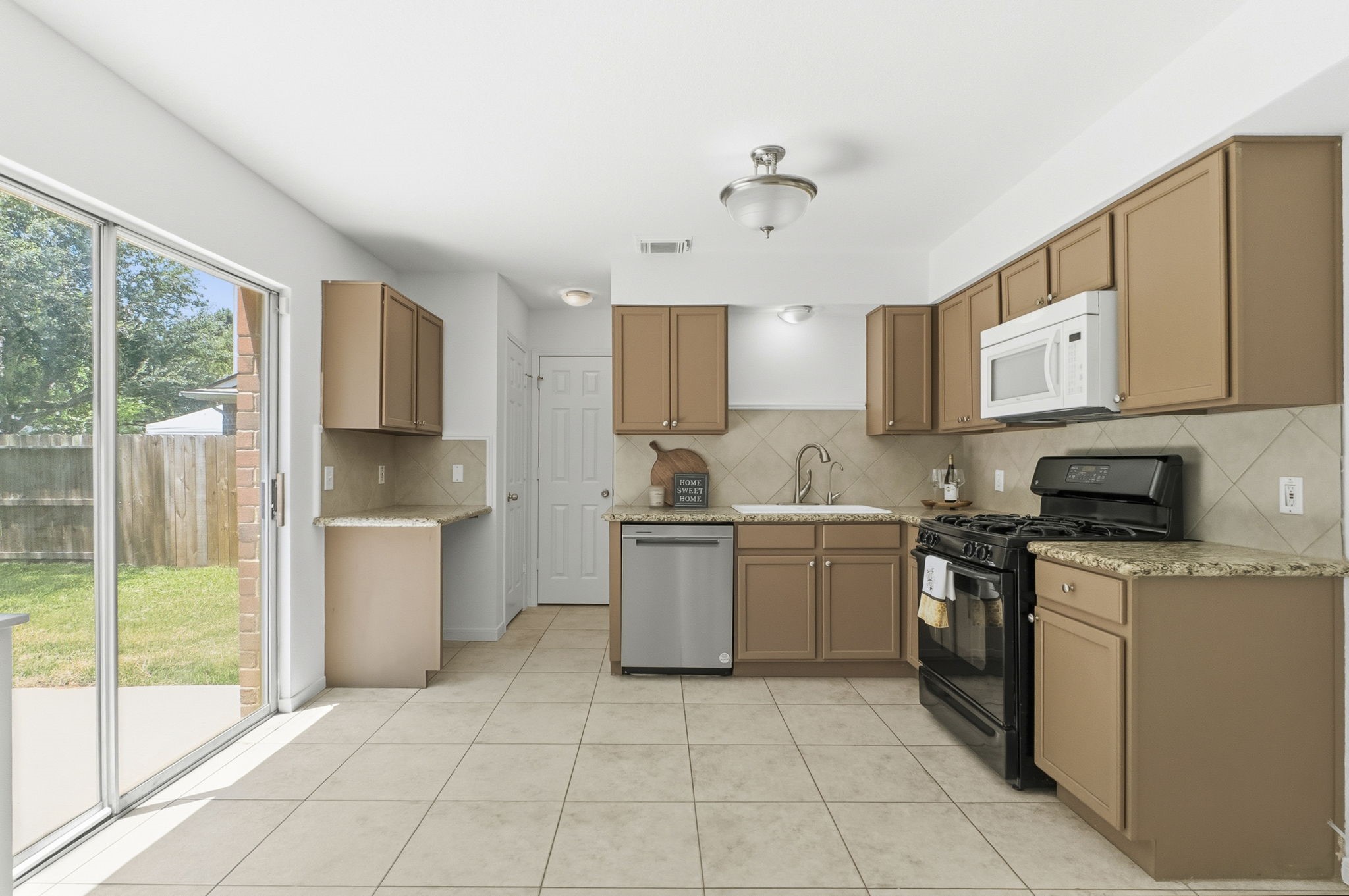 11907 Ezekiel Road Tomball, TX 77375 - Photo 11 of 39 a kitchen with a sink a counter top space and stainless steel appliances