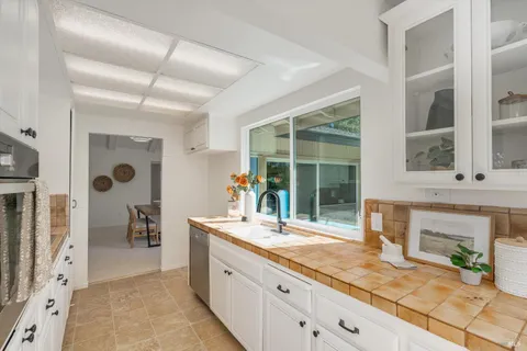 a bathroom with a granite countertop sink mirror and a shower