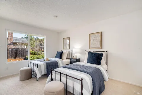a bedroom with two beds and a large window