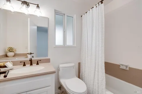 a bathroom with a sink a toilet and shower curtain