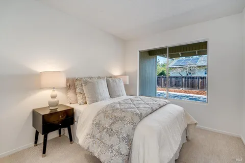 a bedroom with a bed and a lamp next to a window