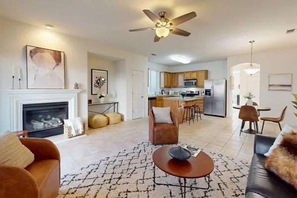 a living room with furniture a fireplace and a chandelier