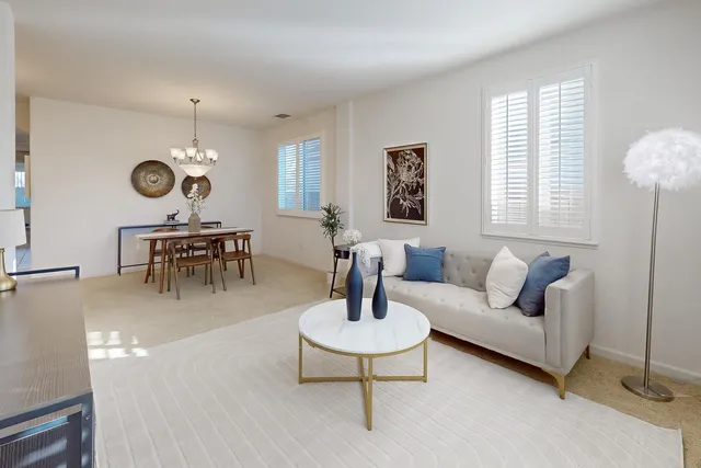 a living room with furniture a clock and a chandelier