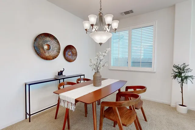 a kitchen with granite countertop a stove a sink a dining table and chairs