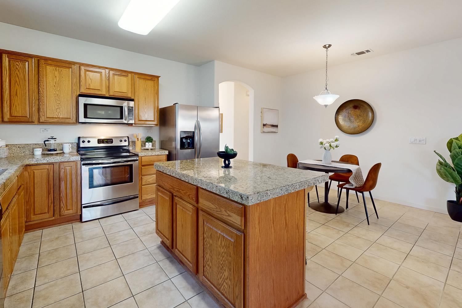 1920 Indiana Street Gridley, CA 95948 - Photo 30 of 66 a kitchen with granite countertop a stove a sink a dining table and chairs