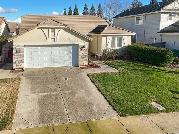 a front view of a house with a yard and potted plants