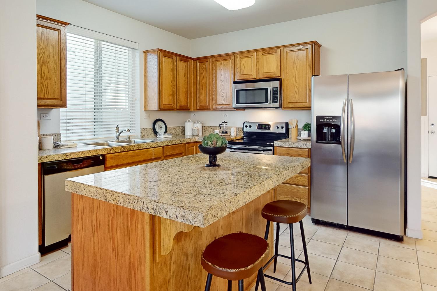 1920 Indiana Street Gridley, CA 95948 - Photo 31 of 66 a kitchen with stainless steel appliances granite countertop a sink a microwave a refrigerator and chairs