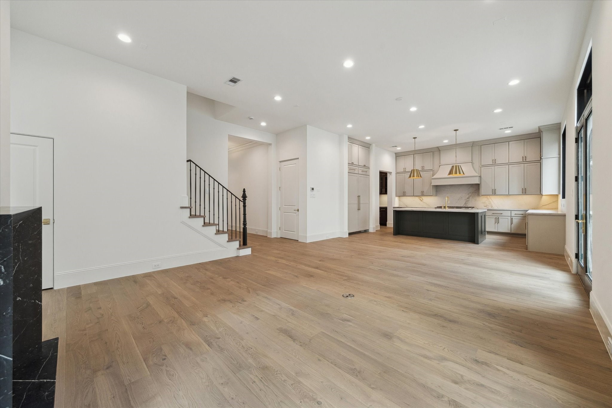 25 Wentworth Gate Path Houston, TX 77027 - Photo 6 of 32 The stunning first floor was designed with relaxation and entertaining in mind! Spacious enough for ample seating surrounding the fireplace, a large dining table, and an island with additional seating that overlooks the living space.