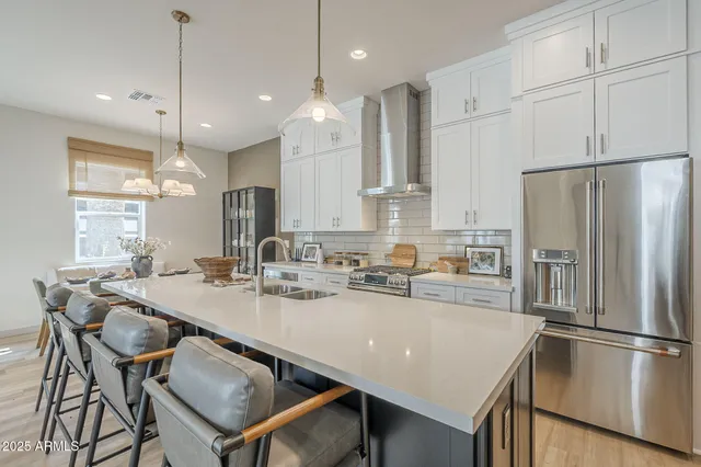 a kitchen with kitchen island a appliances dining table and chairs