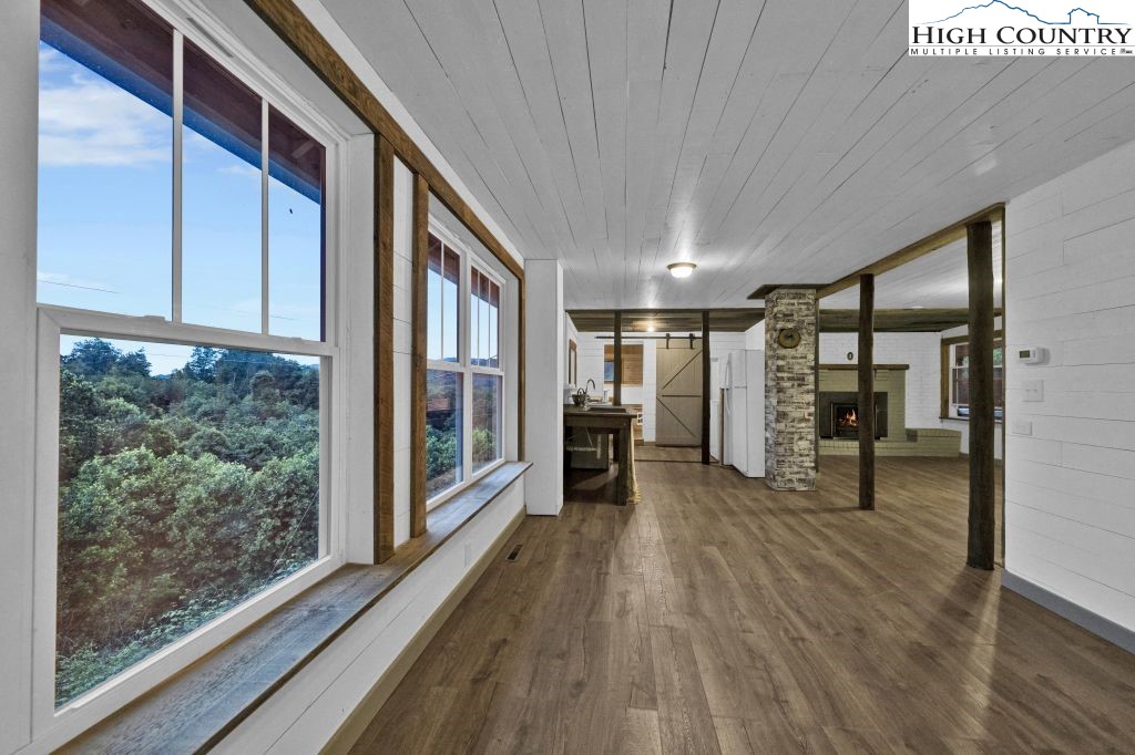 244 Flat Springs Road Elk Park, NC 28622 - Photo 12 of 47 a view of a hallway with wooden floor and furniture