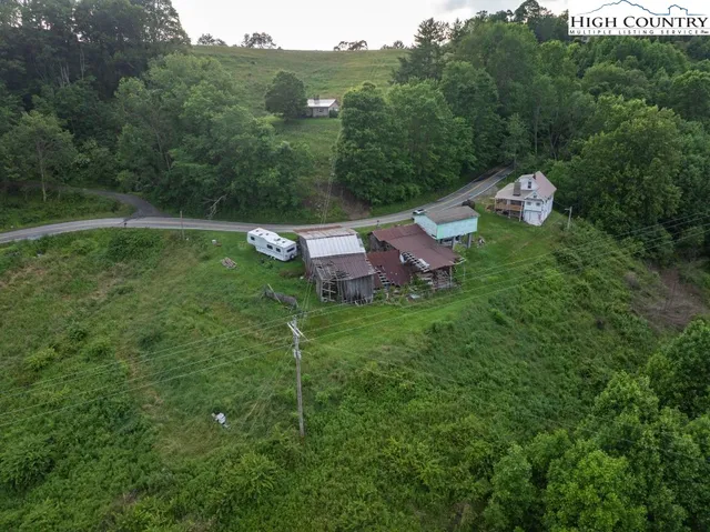 a view of a house with a big yard and large trees