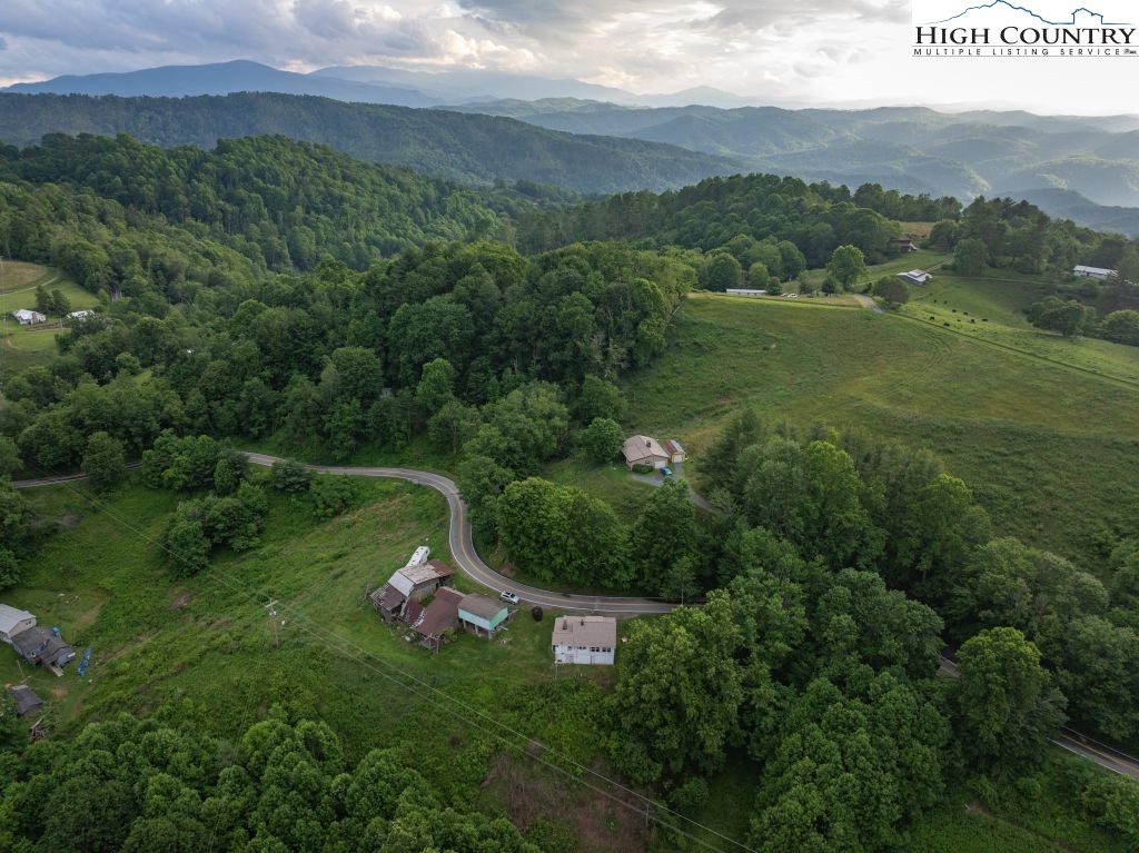 244 Flat Springs Road Elk Park, NC 28622 - Photo 6 of 47 a view of a lush green hillside and houses