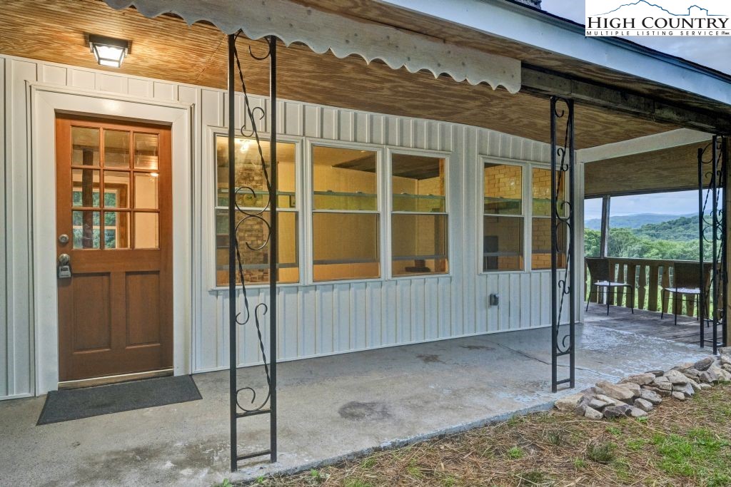 244 Flat Springs Road Elk Park, NC 28622 - Photo 8 of 47 a view of a porch with a table and chairs