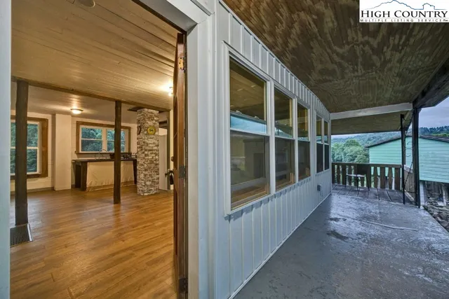 a view of empty room with wooden floor and large window