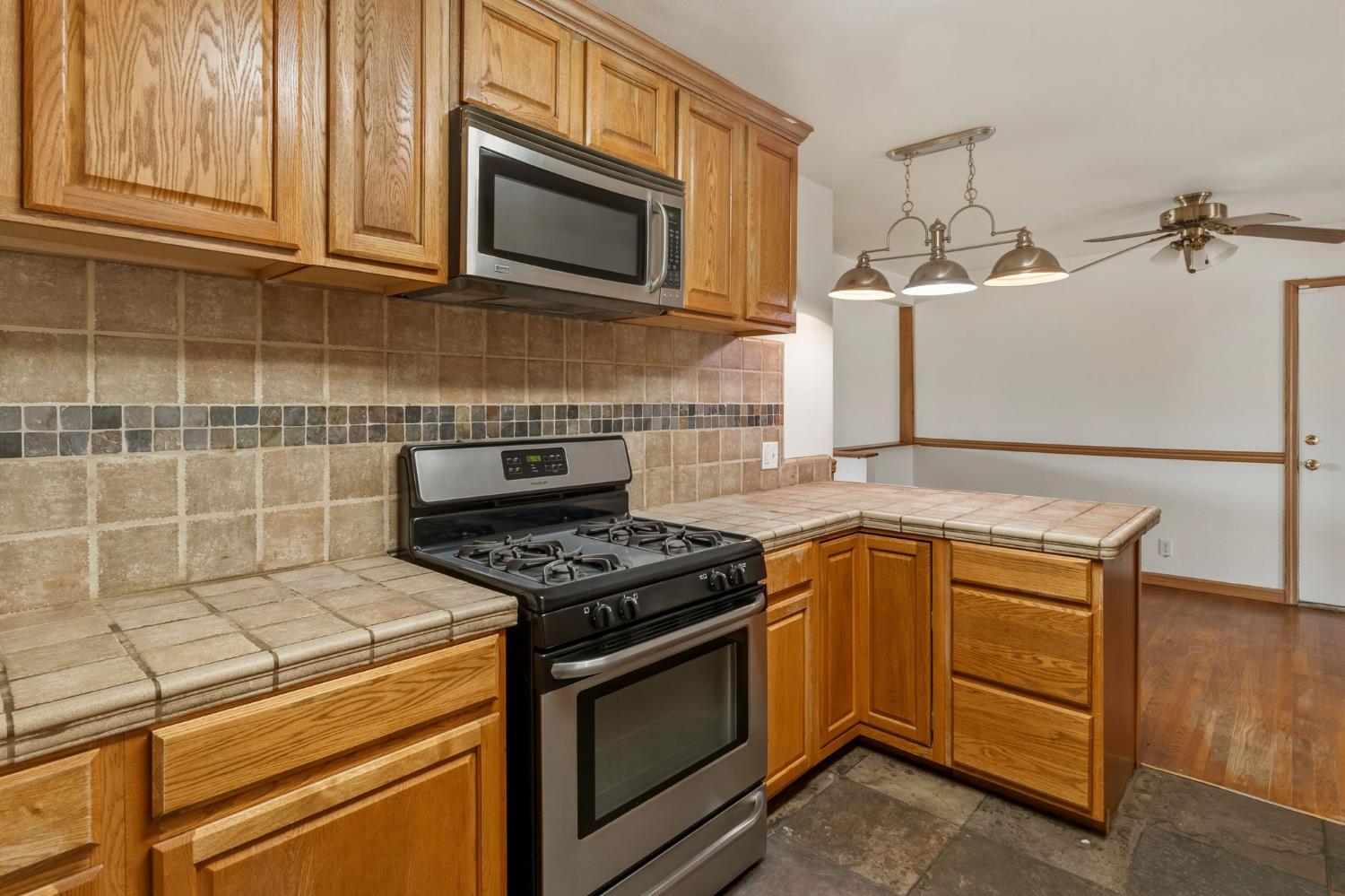 1805 Aloha Way Modesto, CA 95350 - Photo 4 of 24 a kitchen with stainless steel appliances granite countertop a stove and a microwave