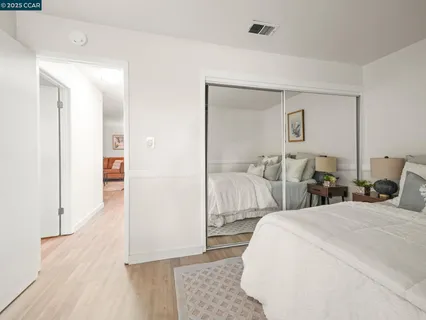 a bedroom with a bed and wooden floor