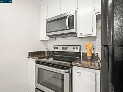 a kitchen with stainless steel appliances granite countertop a stove microwave and refrigerator