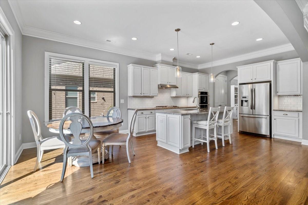 8131 Clems Branch Road Indian Land, SC 29707 - Photo 16 of 47 a kitchen with stainless steel appliances kitchen island granite countertop a dining table chairs and white cabinets