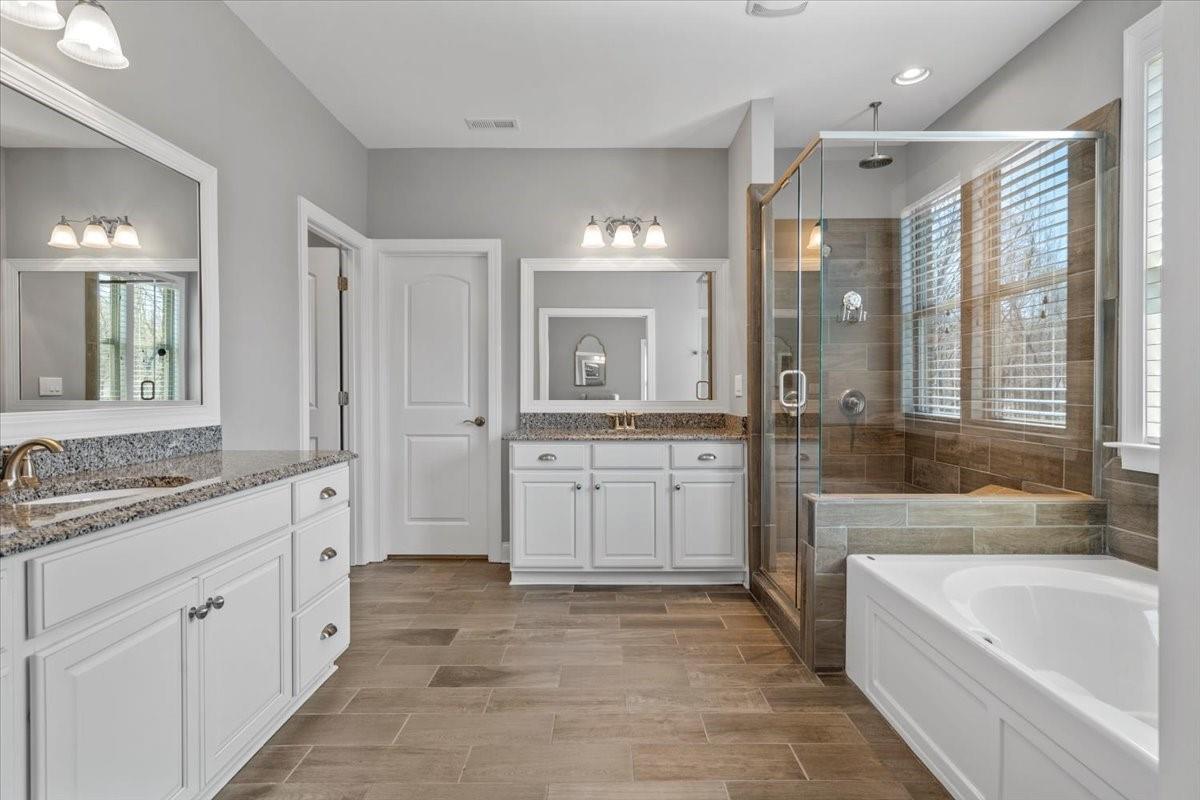 8131 Clems Branch Road Indian Land, SC 29707 - Photo 32 of 47 a spacious bathroom with a double vanity sink a mirror a bathtub and shower