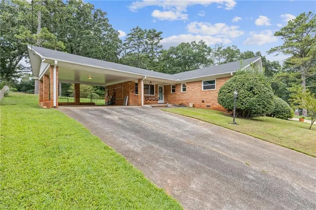 a front view of a house with a big yard and potted plants