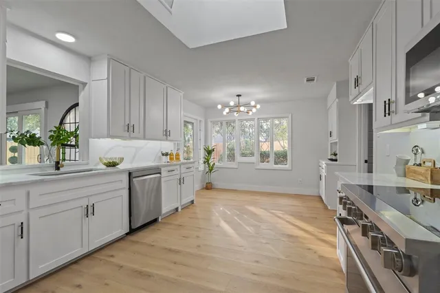 a large kitchen with stainless steel appliances a lot of counter space and wooden floor