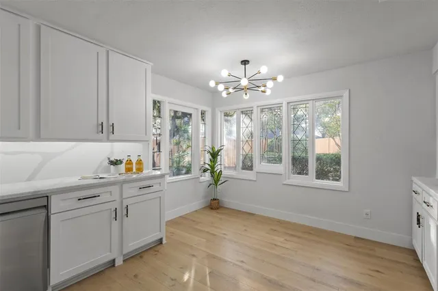 a view of a kitchen sink and dishwasher with wooden floor