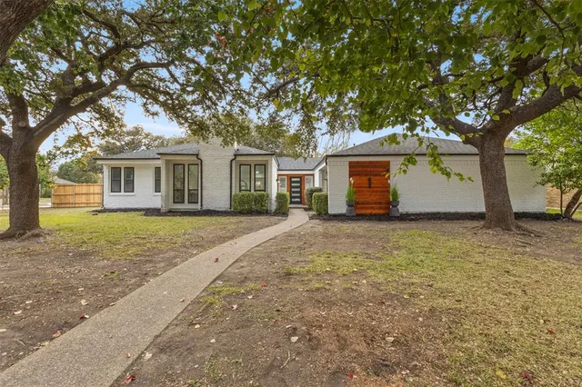 a front view of house with yard and trees around
