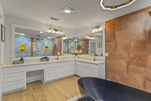 a large bathroom with a double vanity sink a mirror and a bathtub