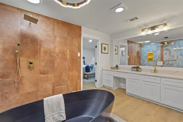 a large bathroom with a tub sink and mirror
