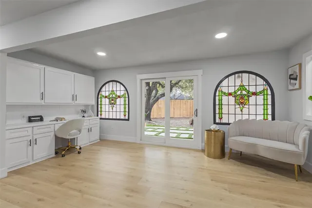 a living room with furniture a rug a flat screen tv and a large window