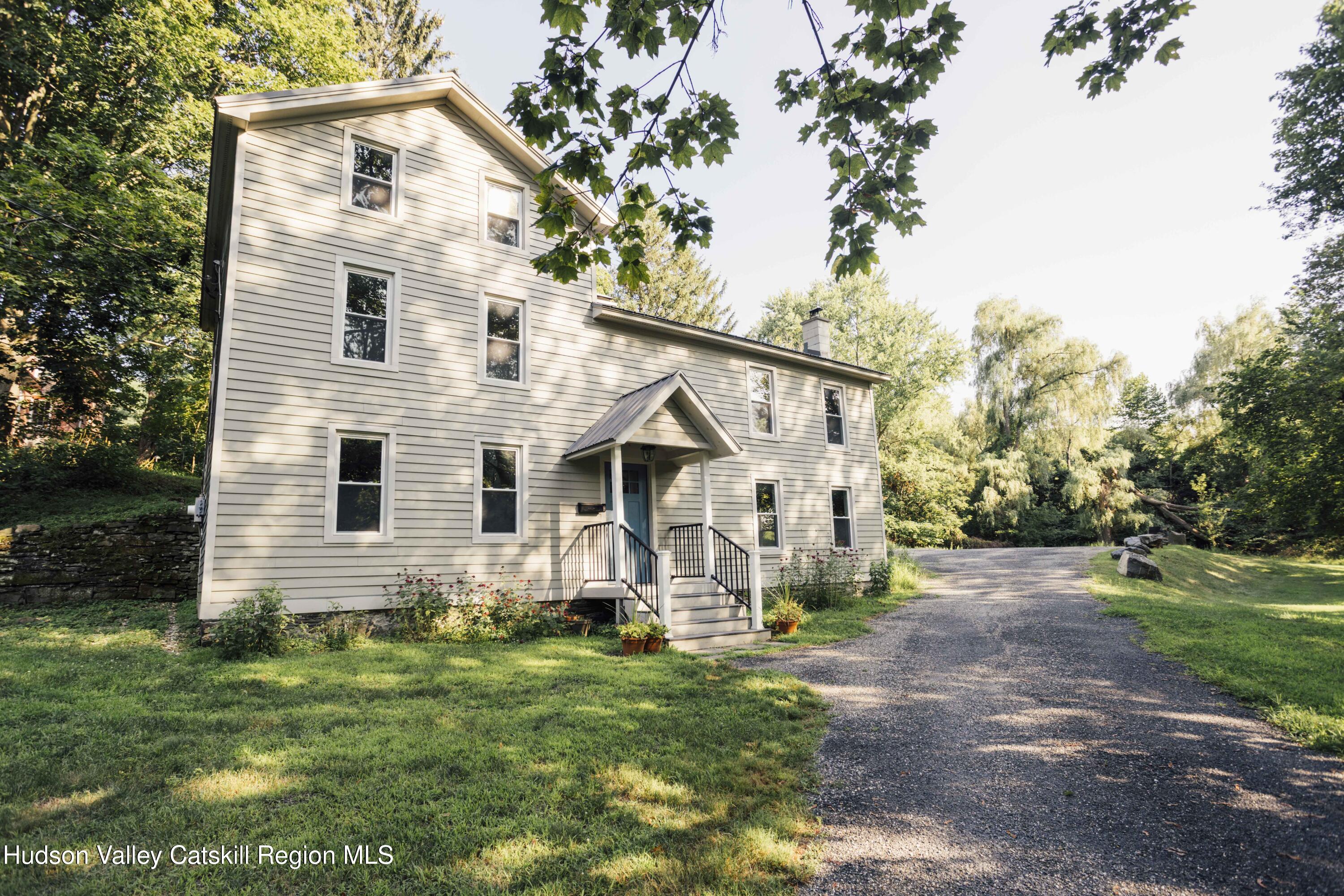 a view of house with a yard and pathway